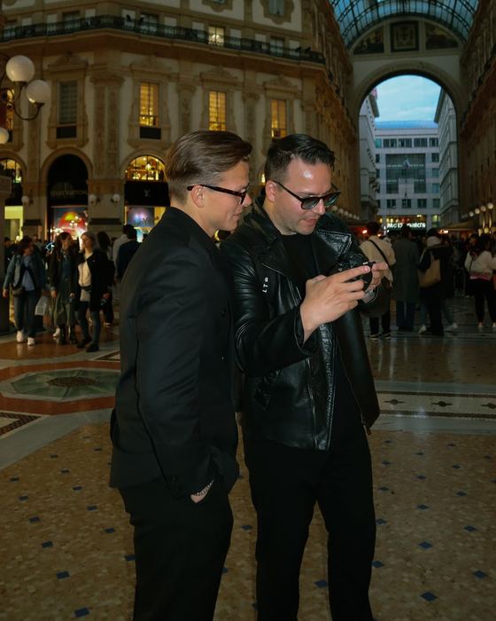Two of the Artzmen Creative team checking a phone in a Milan galleria